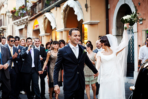 Matrimonio a Taormina. Corteo di amici con gli sposi a Corso Umberto, foto per matrimonio di Nino Lombardo