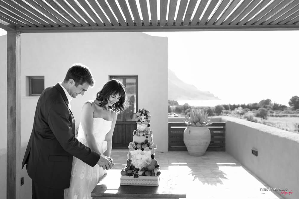 Fotografia taglio wedding cake tema Sicilia per matrimonio a Castelluzzo